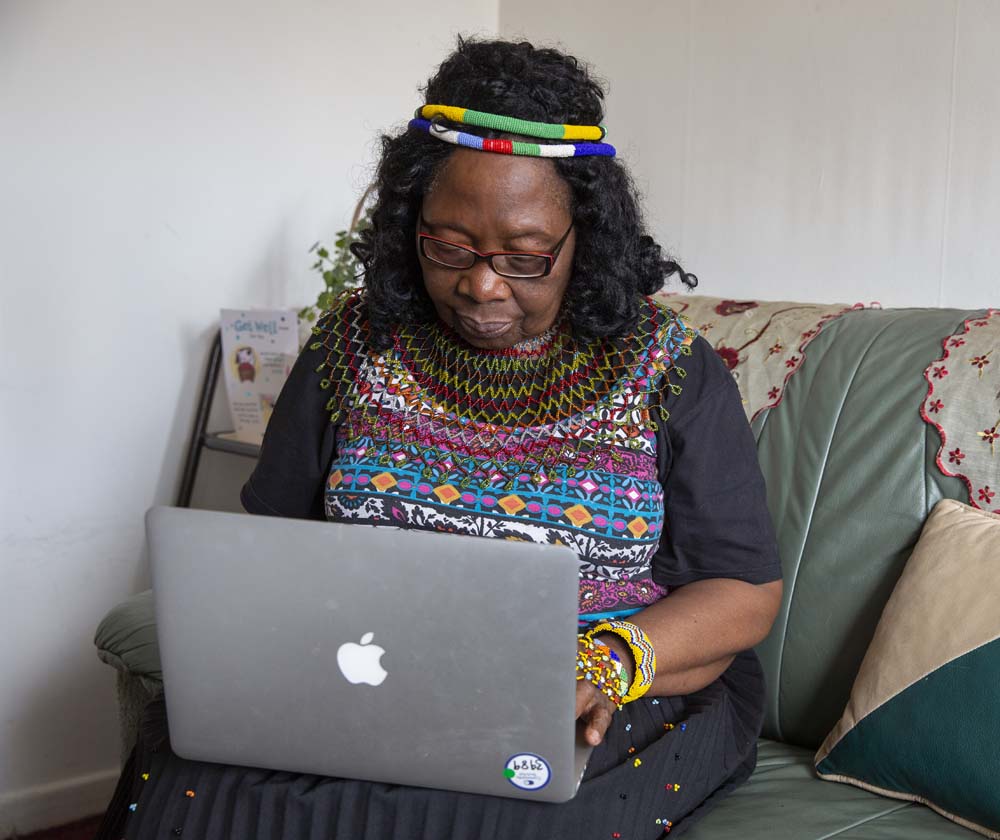 Lady sitting on sofa using laptop.